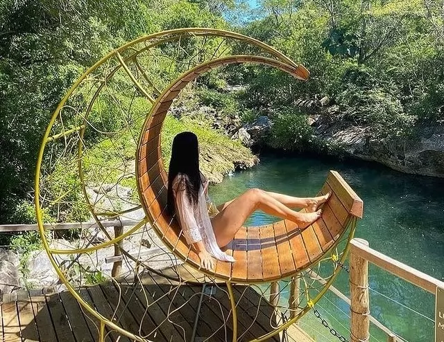 Turista fazendo pose para foto às margens do Rio Mimoso